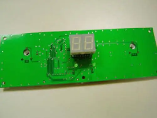 Grüne Leiterplatte mit digitalen Anzeigefeldern und elektronischen Verbindungen, Teil einer Zentraleinheit von Remeha.